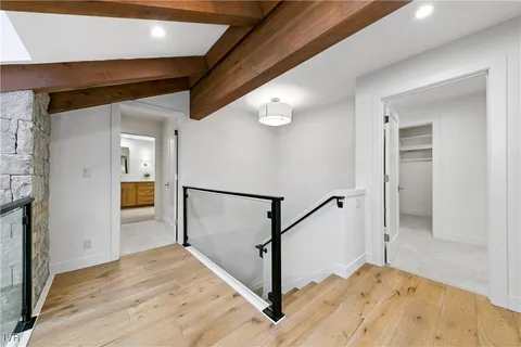 a view of hallway with stairs and wooden floor