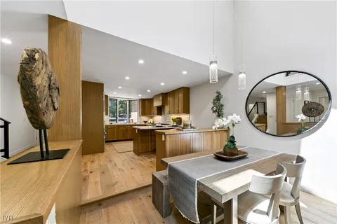a living room with furniture a mirror and kitchen view