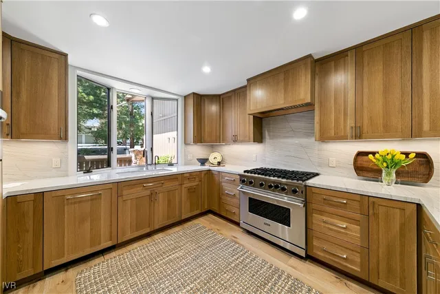 a kitchen with stainless steel appliances granite countertop wooden cabinets a stove a sink and dishwasher