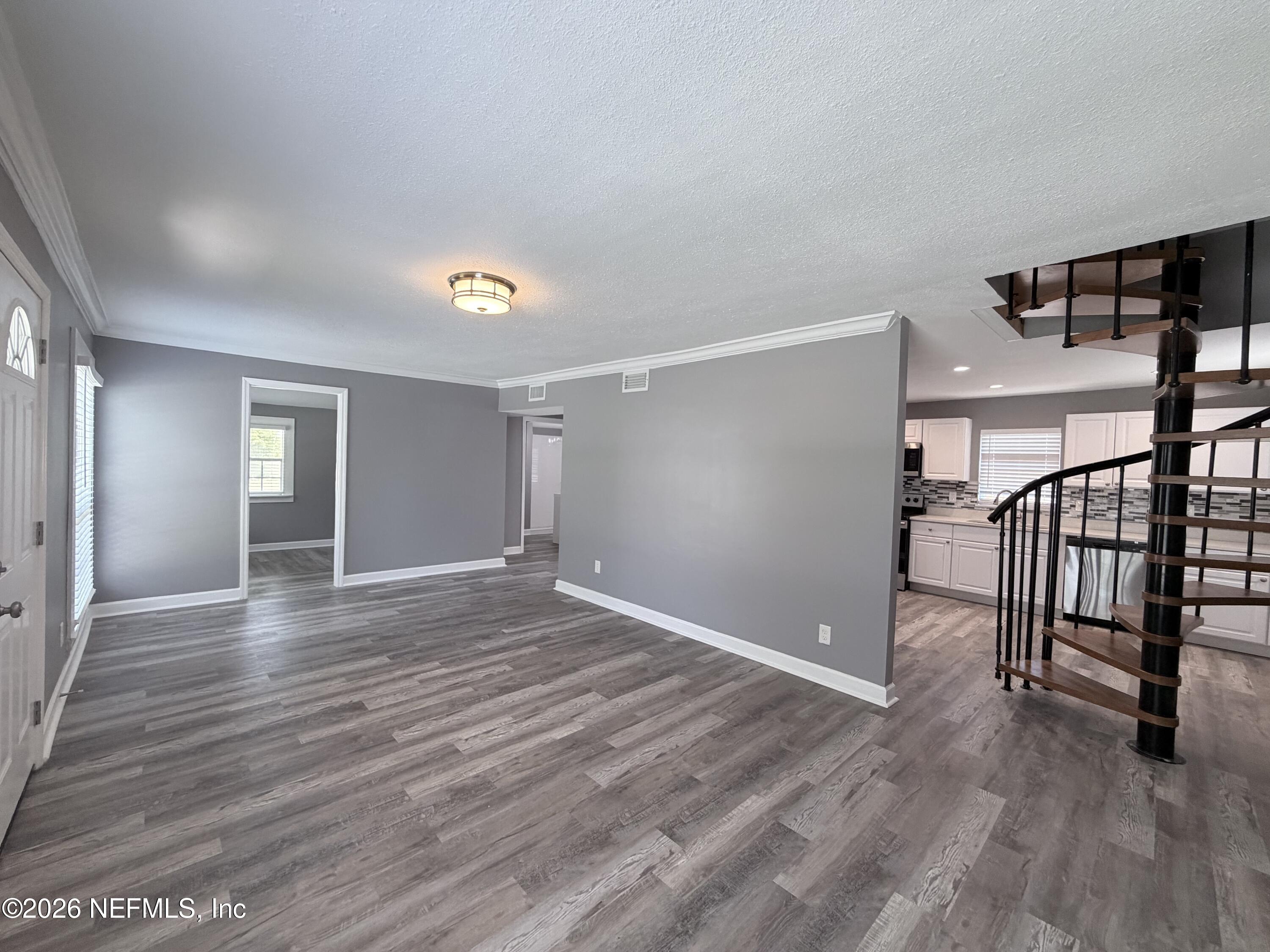 5336 Cruz Road Jacksonville, FL 32207 - Photo 5 of 29 a view of an empty room with wooden floor and stairs