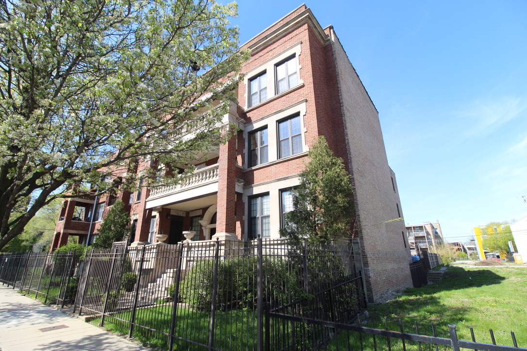 5528 South Indiana Avenue, Unit 2 Chicago, IL 60637 - Photo 1 of 3 a view of a brick building next to a yard