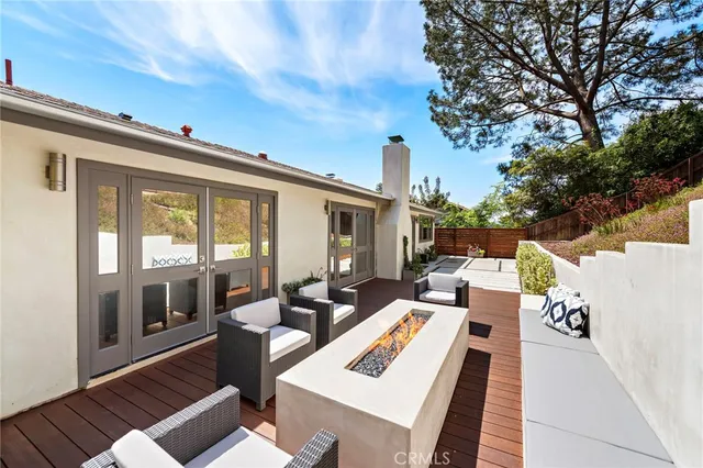 a view of a patio with couches table and chairs with wooden floor and fence