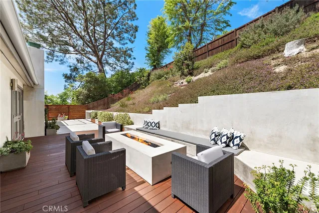 a roof deck with couches and wooden floor