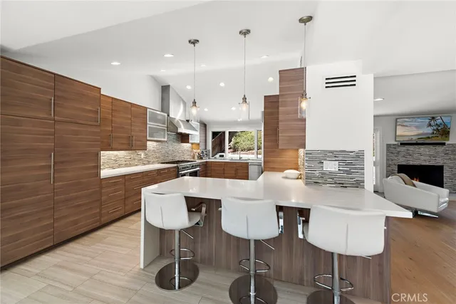 a kitchen with stainless steel appliances kitchen island granite countertop a table chairs and a wooden floor