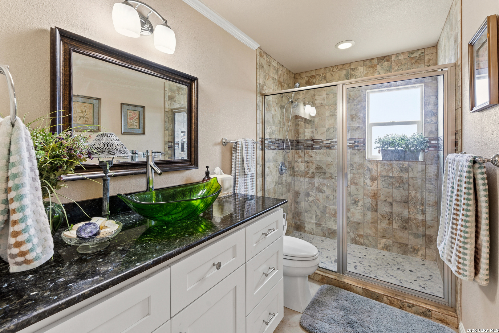 4515 Stapper Road St. Hedwig, TX 78152 - Photo 24 of 64 a bathroom with a granite countertop sink a toilet a mirror and shower