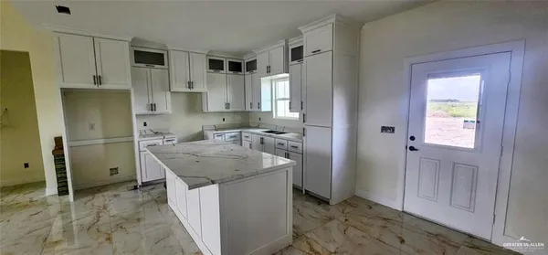 a kitchen with stainless steel appliances granite countertop a sink and a refrigerator