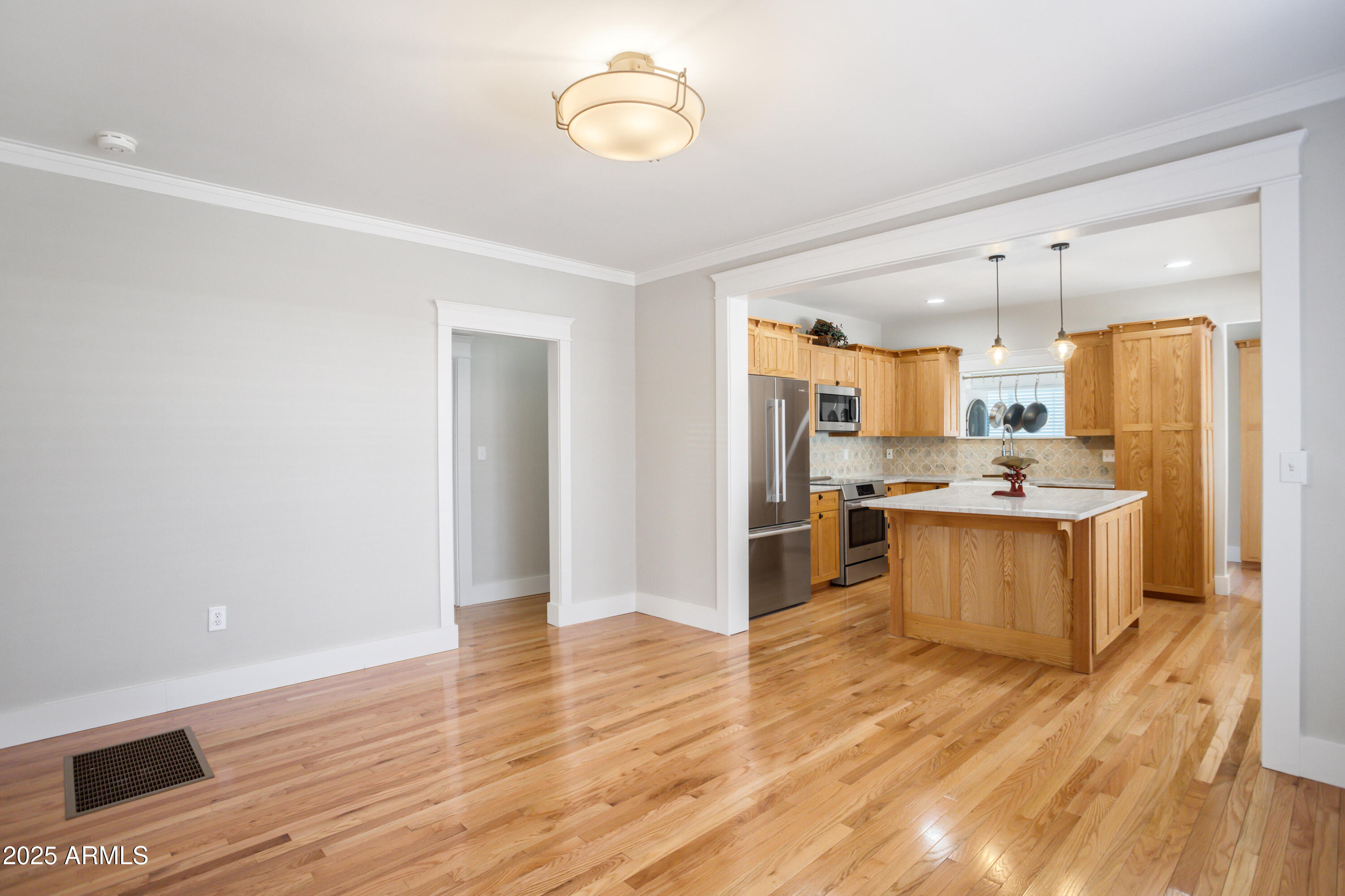 400 Powell Street Bisbee, AZ 85603 - Photo 13 of 57 a large kitchen with a center island wooden floor stainless steel appliances and windows