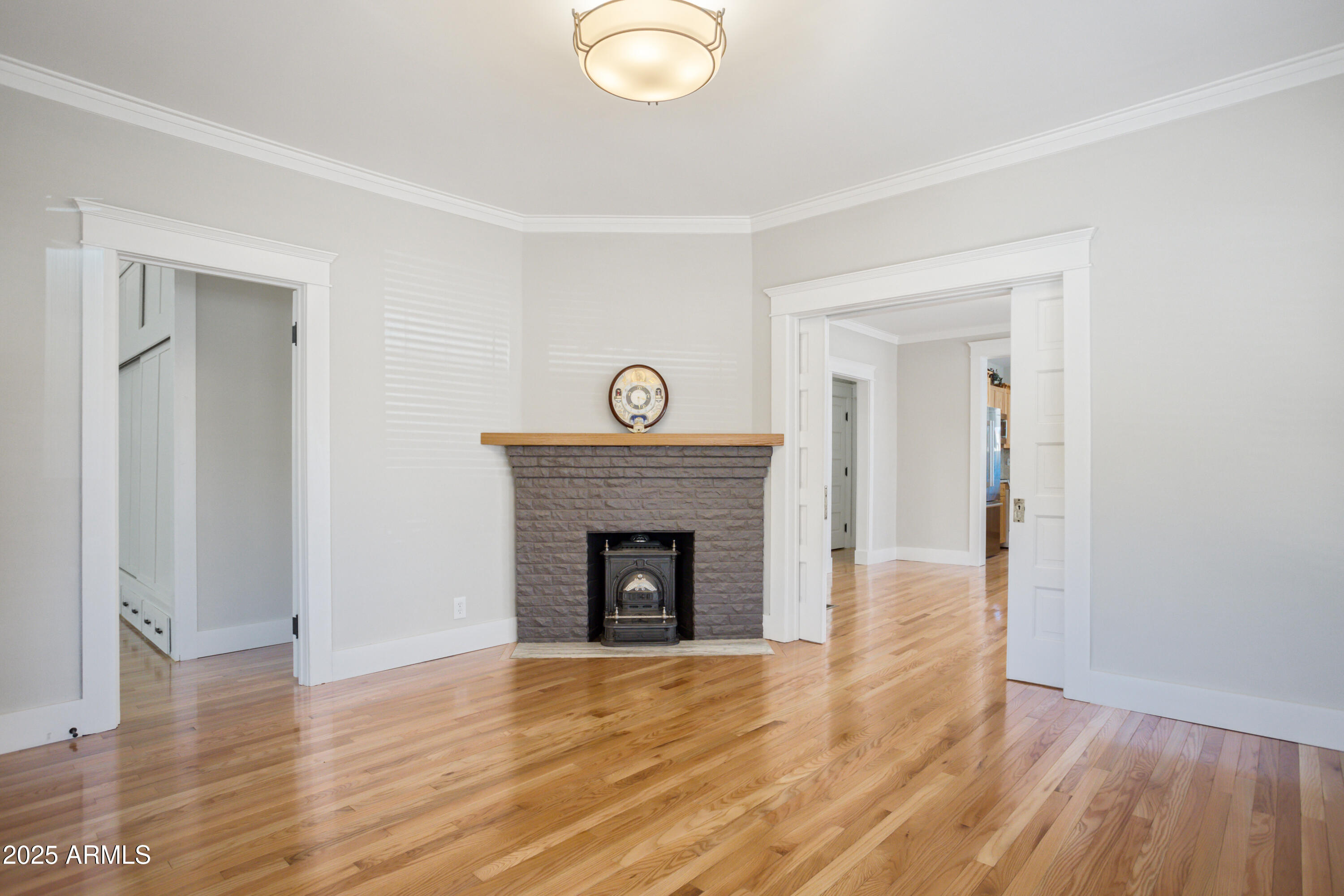 400 Powell Street Bisbee, AZ 85603 - Photo 9 of 57 an empty room with wooden floor and a fireplace