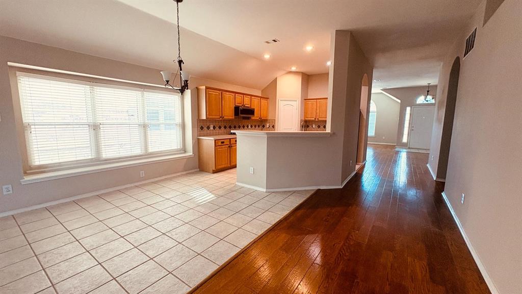 5970 Dustin Trail Frisco, TX 75034 - Photo 16 of 31 Open concept dining area featuring a large window, tiled flooring, and a chandelier