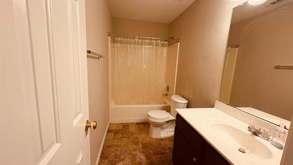 5970 Dustin Trail Frisco, TX 75034 - Photo 24 of 31 Bathroom featuring a dark wood-finish vanity with a white countertop and integrated sink, a large wall-mounted mirror, a white toilet, and a white bathtub with a shower combination
