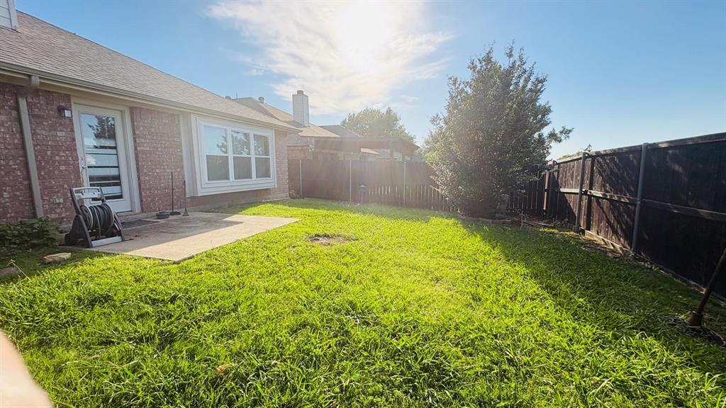 5970 Dustin Trail Frisco, TX 75034 - Photo 29 of 31 Spacious backyard featuring a concrete patio, a red brick exterior, a bay window, and a wooden privacy fence