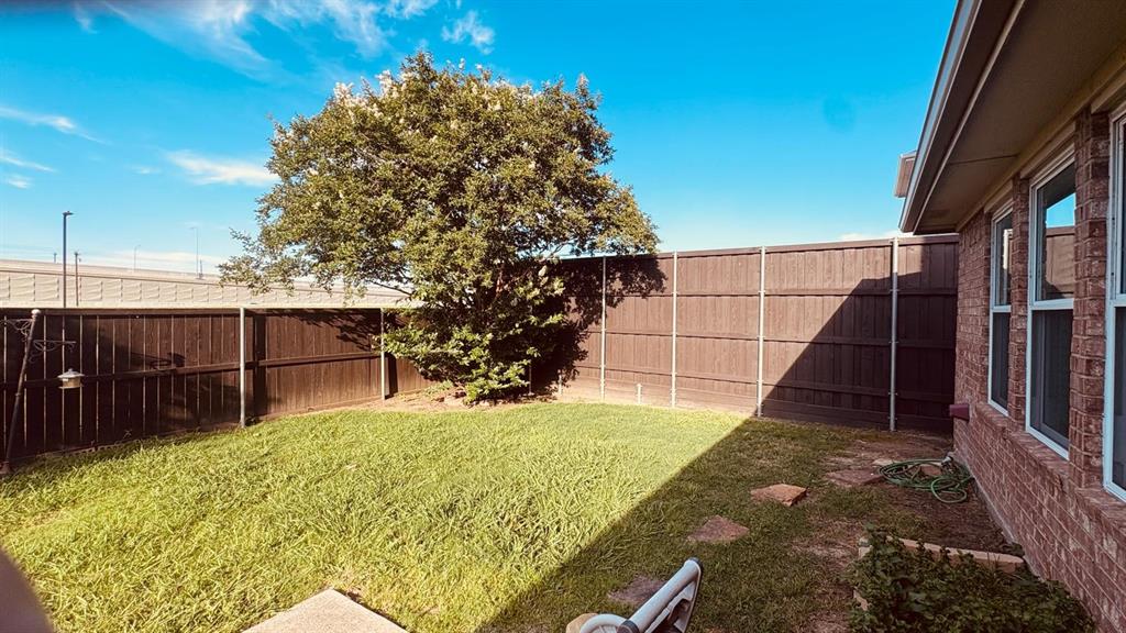 5970 Dustin Trail Frisco, TX 75034 - Photo 30 of 31 Expansive backyard featuring a mature shade tree, a full wood privacy fence, and a brick exterior wall with multiple windows