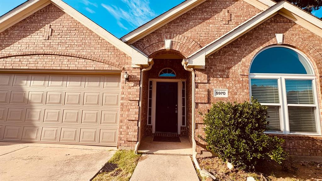 5970 Dustin Trail Frisco, TX 75034 - Photo 3 of 31 Brick facade residence featuring an arched entryway, an arched window, and an attached two-car garage