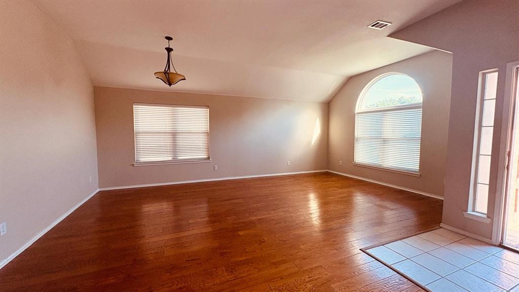 5970 Dustin Trail Frisco, TX 75034 - Photo 4 of 31 Spacious living area featuring wood-finish flooring, vaulted ceilings, and a large arched window