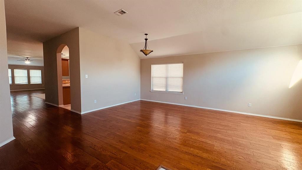 5970 Dustin Trail Frisco, TX 75034 - Photo 5 of 31 Expansive room featuring wood-finish flooring, vaulted ceiling, and neutral wall tones