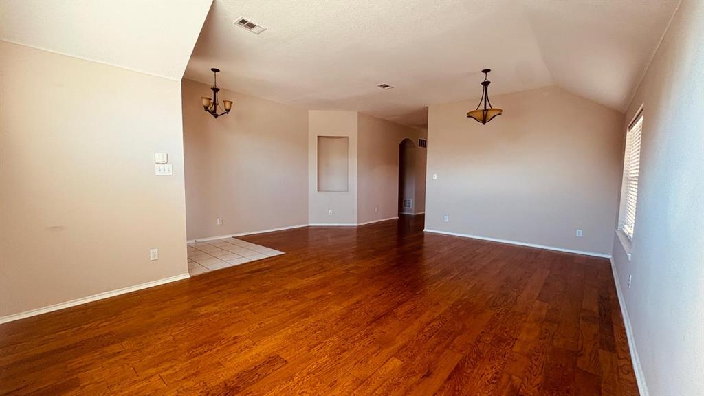 5970 Dustin Trail Frisco, TX 75034 - Photo 6 of 31 Spacious interior featuring wood-finish flooring, vaulted ceilings, and a neutral wall palette