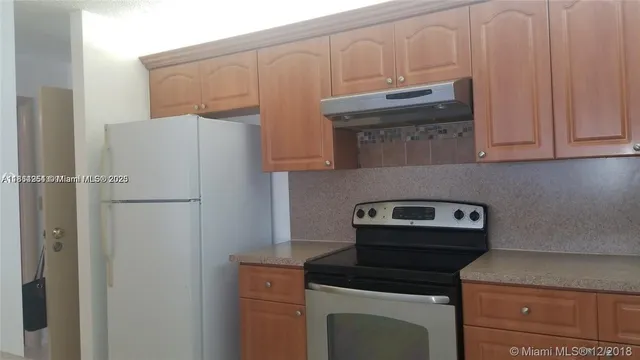 a kitchen with cabinets and a stove top oven