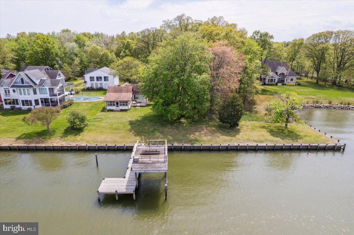 an aerial view of a house with swimming pool and lake view
