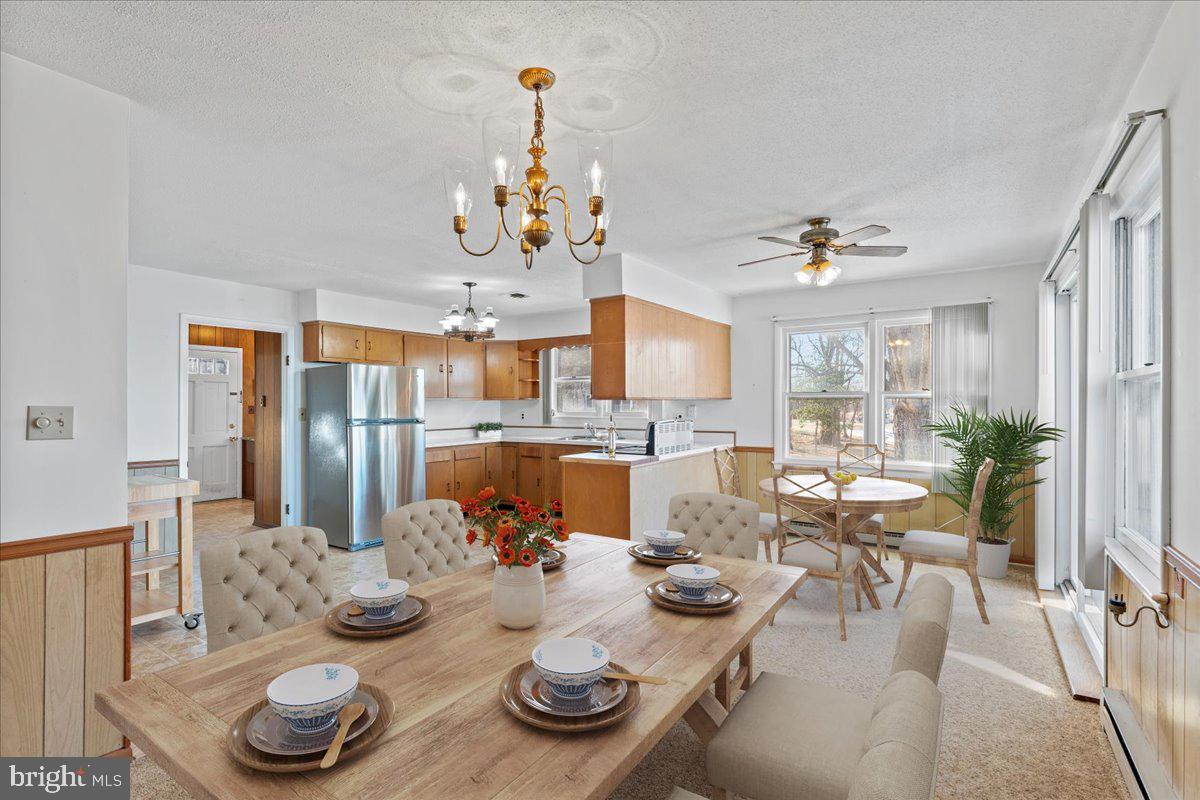 4801 Avery Road Shady Side, MD 20764 - Photo 10 of 25 a view of a dining room with furniture a chandelier and wooden floor