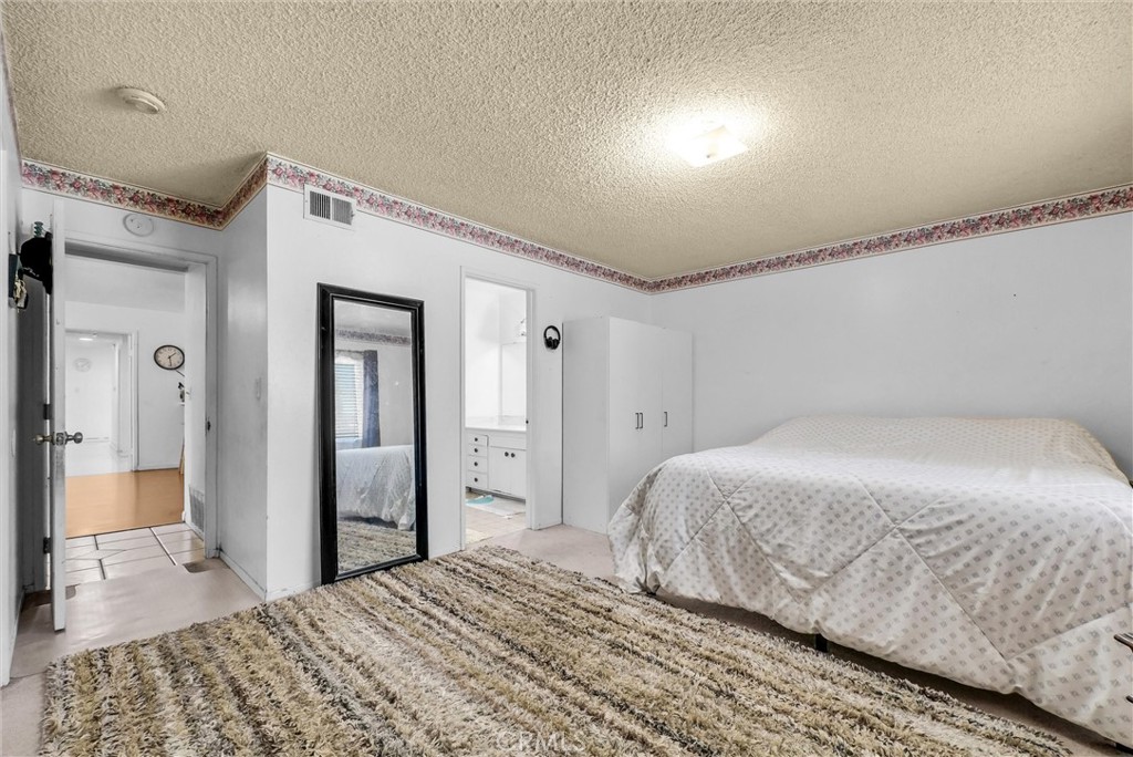 6254 Stanton Avenue Highland, CA 92346 - Photo 16 of 29 a bedroom with a bed and a walk in closet