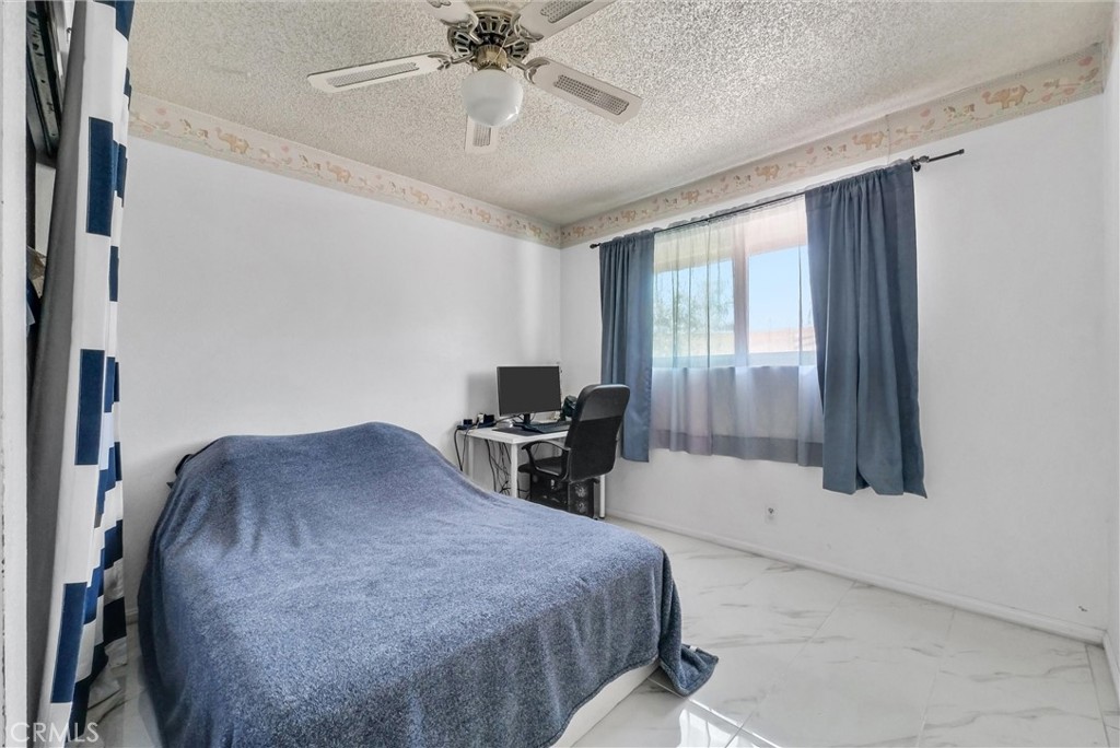 6254 Stanton Avenue Highland, CA 92346 - Photo 21 of 29 a bedroom with a bed and a chandelier