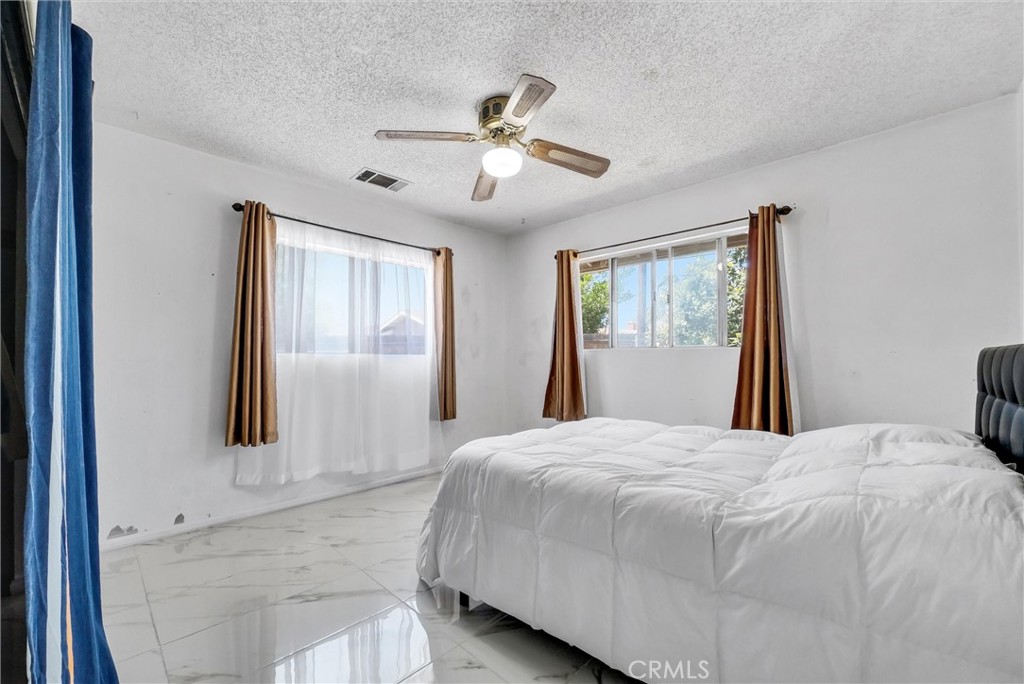6254 Stanton Avenue Highland, CA 92346 - Photo 23 of 29 a bedroom with a large bed and a window