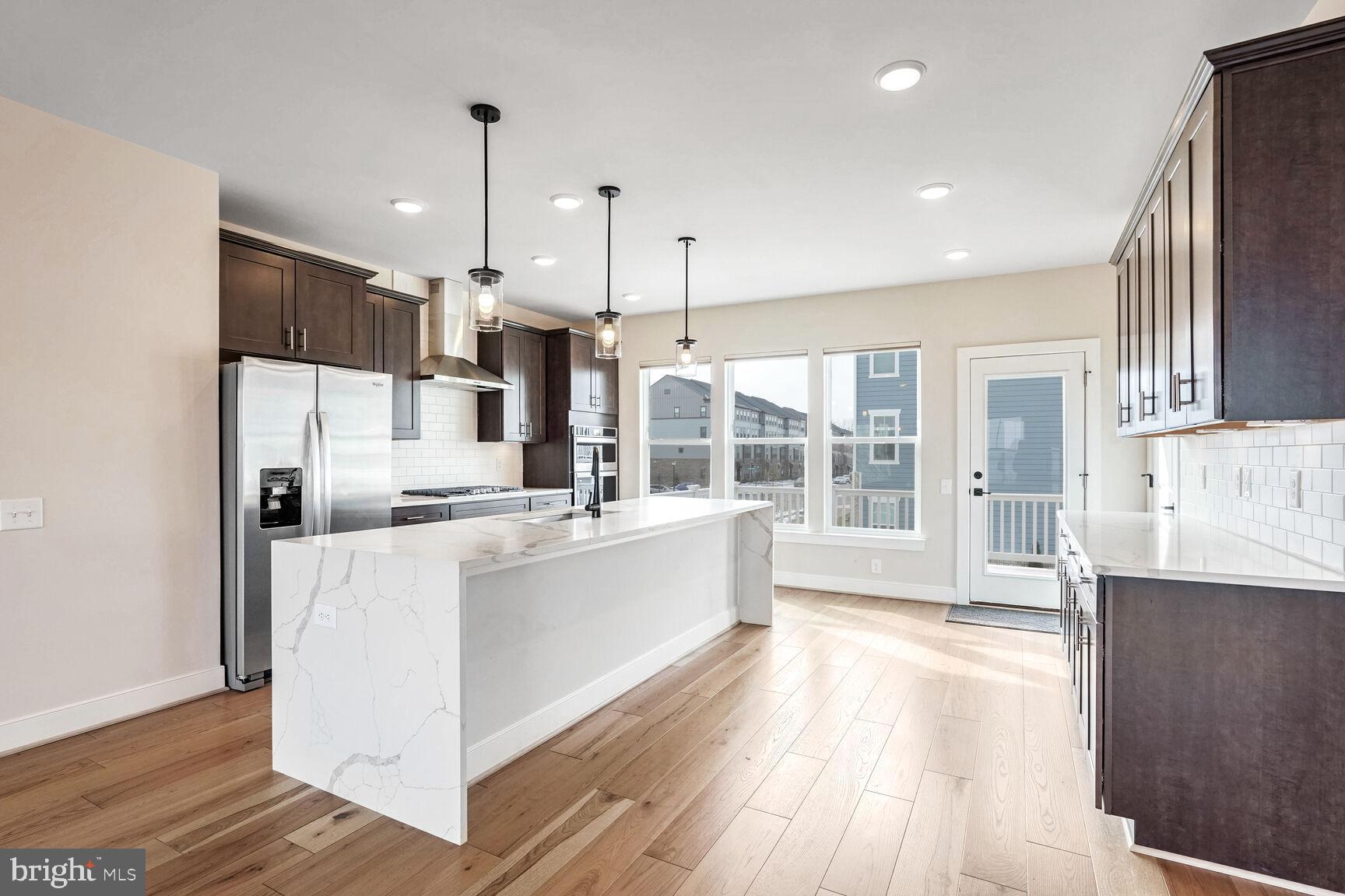 1769 Riverbluff Avenue Dumfries, VA 22026 - Photo 3 of 31 a large kitchen with kitchen island a stove a sink a refrigerator and wooden floor