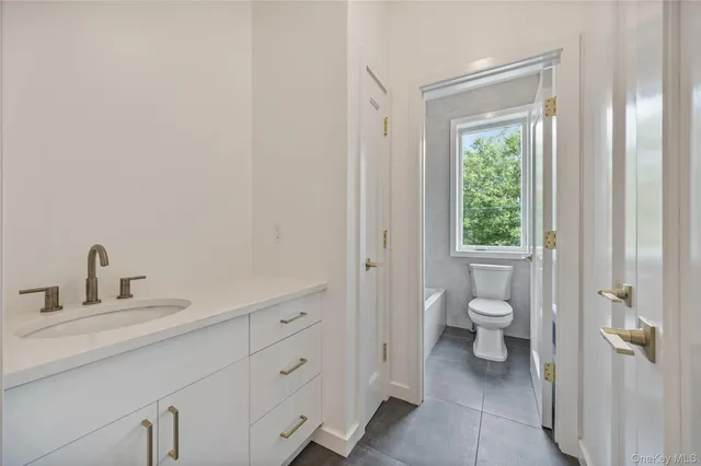 a bathroom with a toilet sink and a mirror
