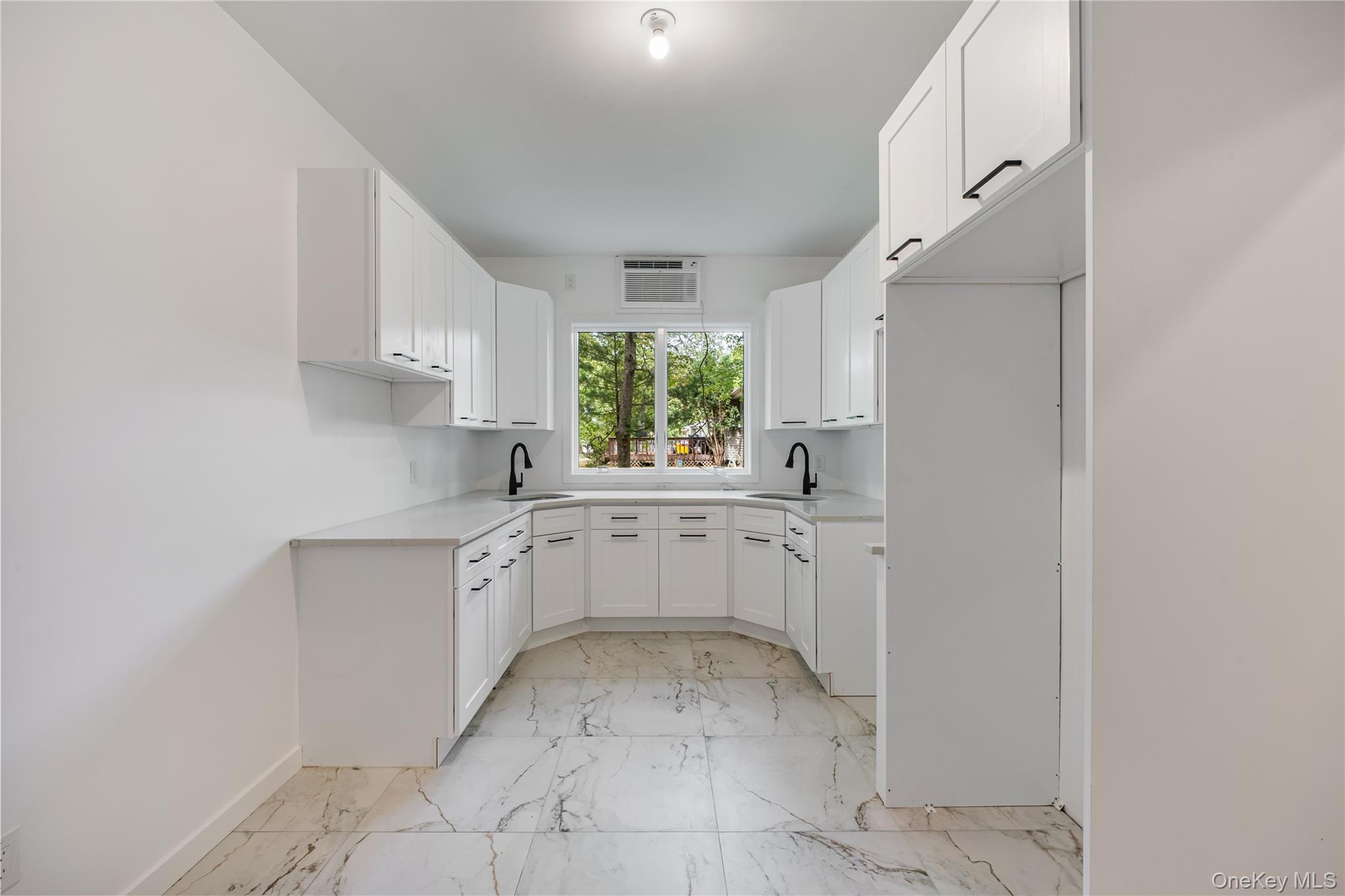 15 Northbrook Road, Unit 201 Spring Valley, NY 10977 - Photo 39 of 50 a kitchen with white cabinets and window