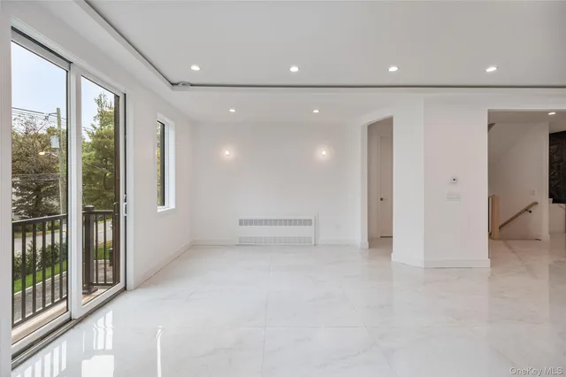 a view of empty room with wooden floor and windows