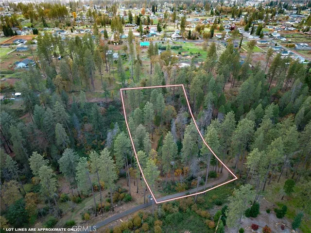 an aerial view of residential houses with outdoor space and trees