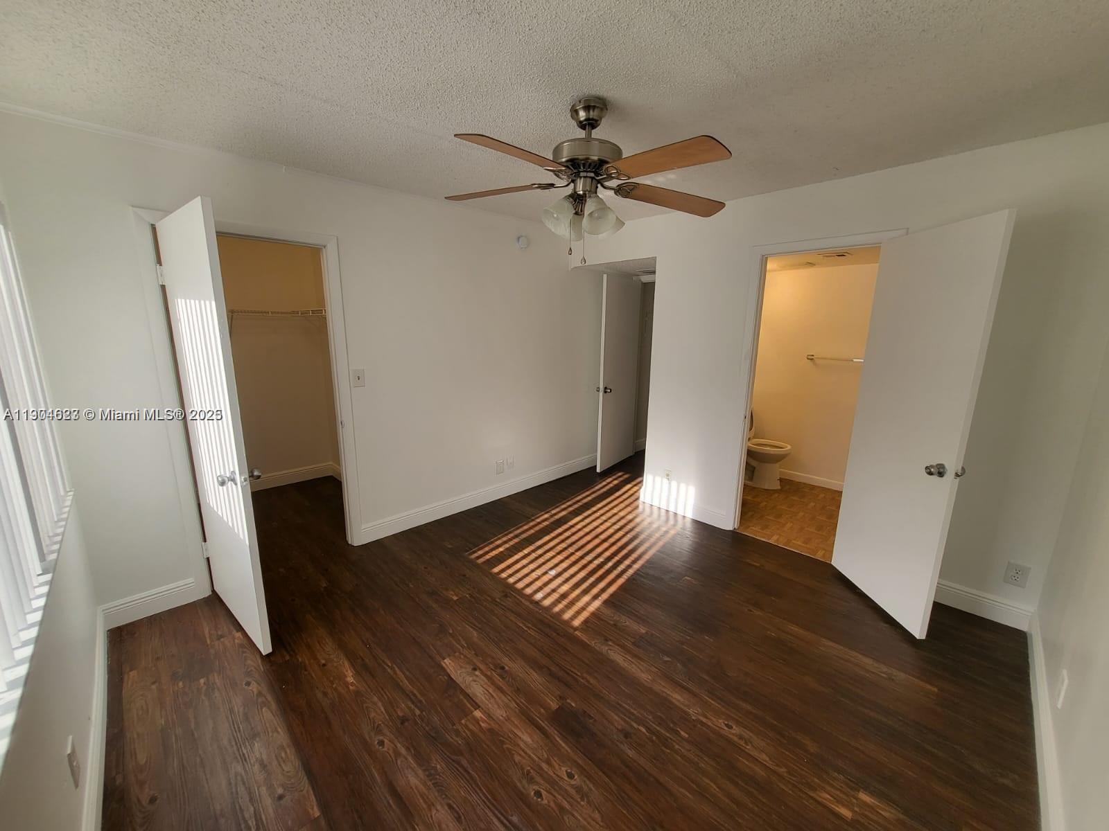 5654 Rock Island Road, Unit 222 Tamarac, FL 33319 - Photo 11 of 21 a view of an empty room with wooden floor and a ceiling fan