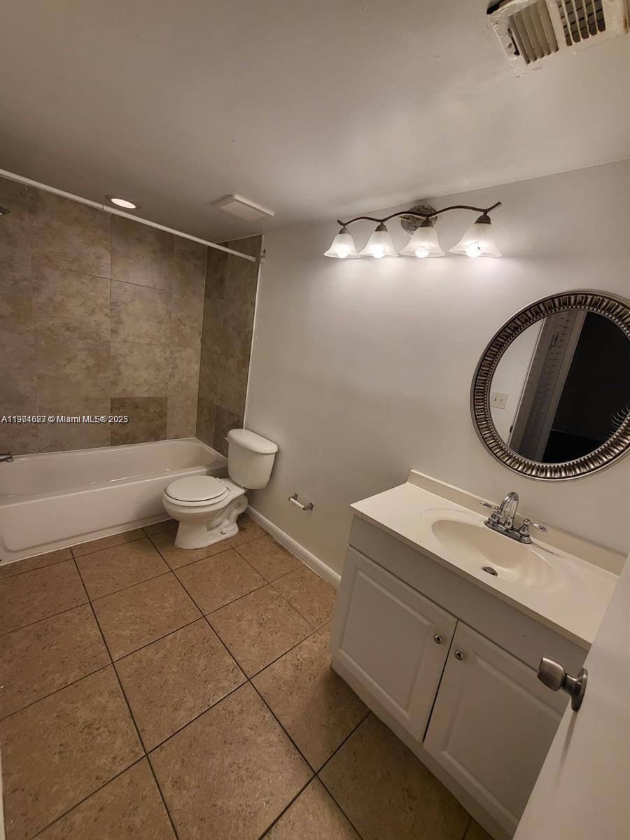 5654 Rock Island Road, Unit 222 Tamarac, FL 33319 - Photo 18 of 21 a bathroom with a sink toilet a mirror and bathtub