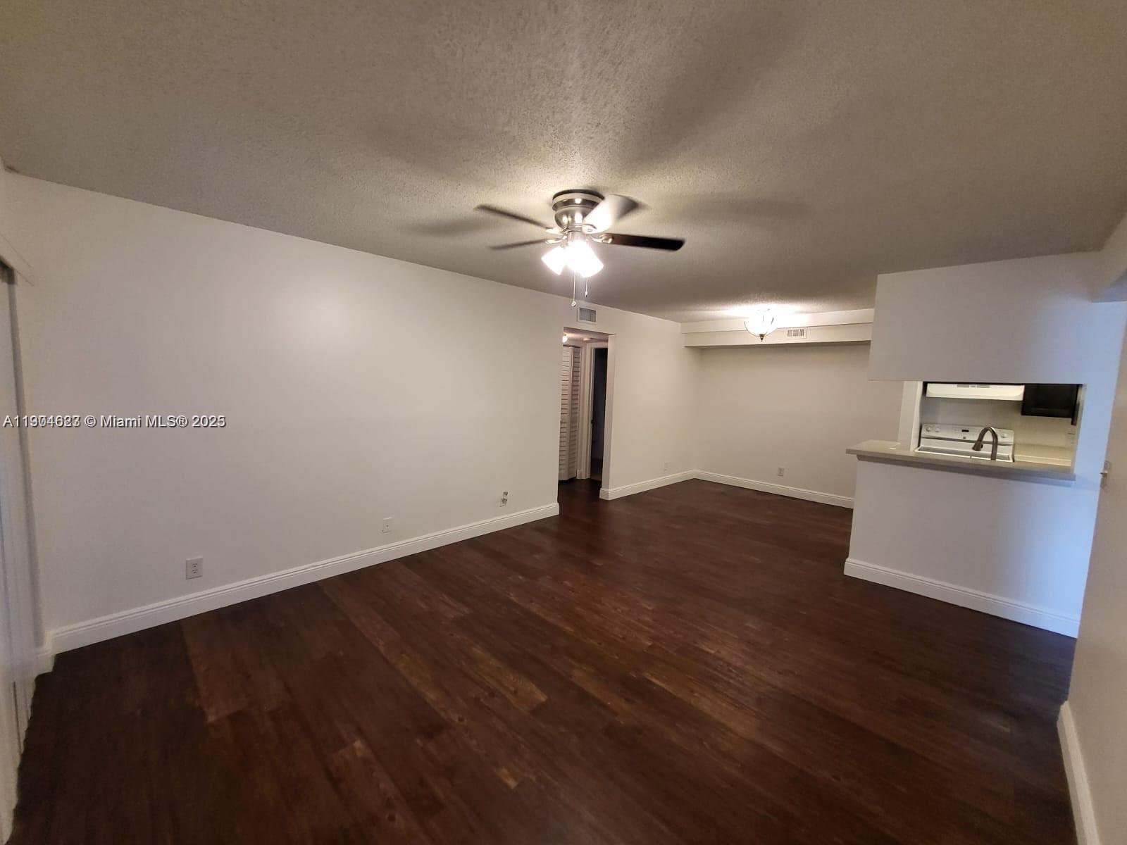 5654 Rock Island Road, Unit 222 Tamarac, FL 33319 - Photo 2 of 21 a view of empty room with wooden floor and ceiling fan