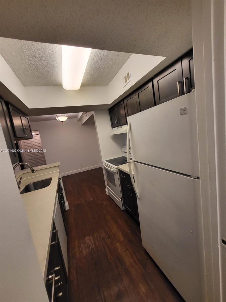 5654 Rock Island Road, Unit 222 Tamarac, FL 33319 - Photo 5 of 21 a view of washer and dryer with wooden floor