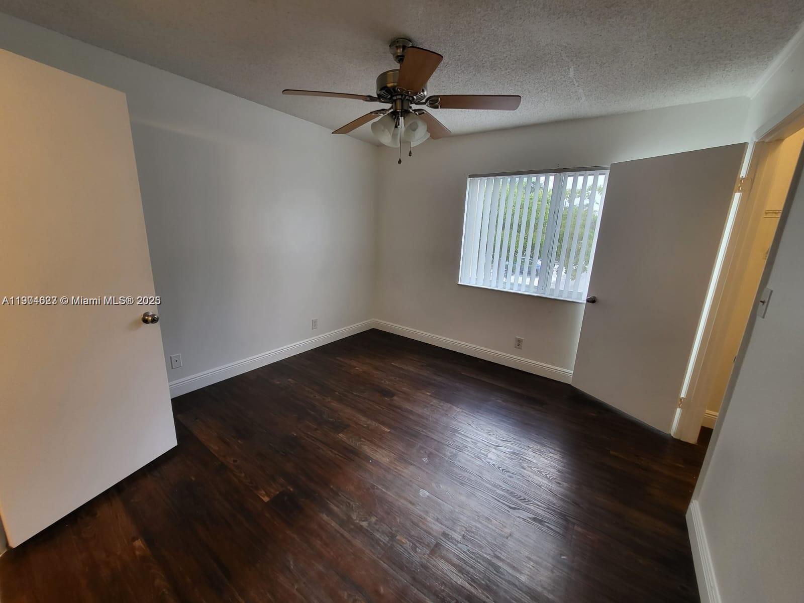 5654 Rock Island Road, Unit 222 Tamarac, FL 33319 - Photo 7 of 21 wooden floor in an empty room with a window