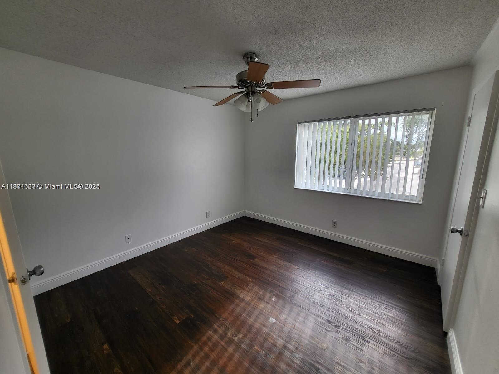 5654 Rock Island Road, Unit 222 Tamarac, FL 33319 - Photo 10 of 21 wooden floor in an empty room with a window