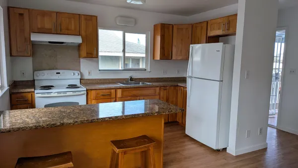 a kitchen with stainless steel appliances granite countertop a refrigerator a stove and a sink