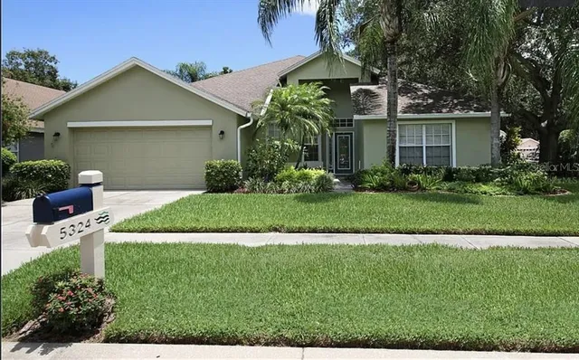 a front view of a house with a yard and potted plants