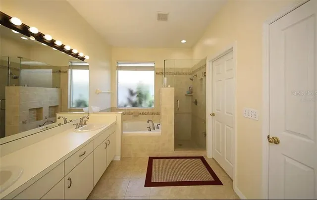 a bathroom with a sink a toilet a mirror and shower