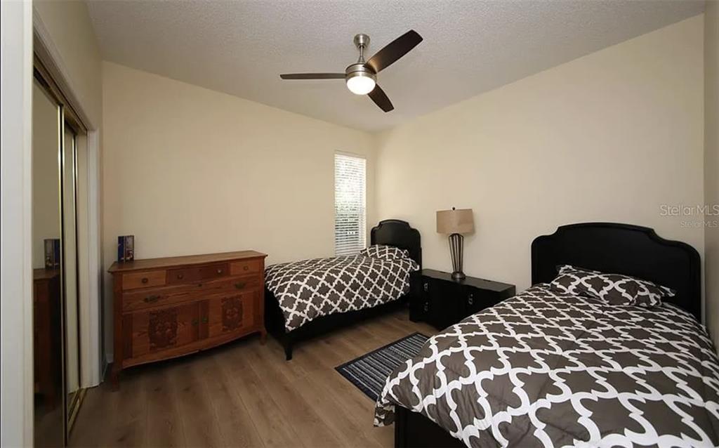 5324 Cottonwood Tree Circle Valrico, FL 33596 - Photo 14 of 27 a bedroom with two beds and a chandelier