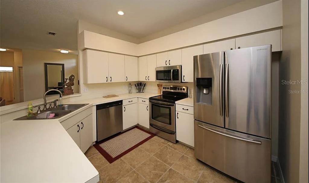 5324 Cottonwood Tree Circle Valrico, FL 33596 - Photo 6 of 27 a kitchen with a refrigerator a sink and a stove top oven