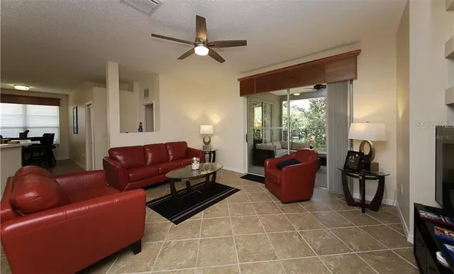 a living room with furniture and a ceiling fan
