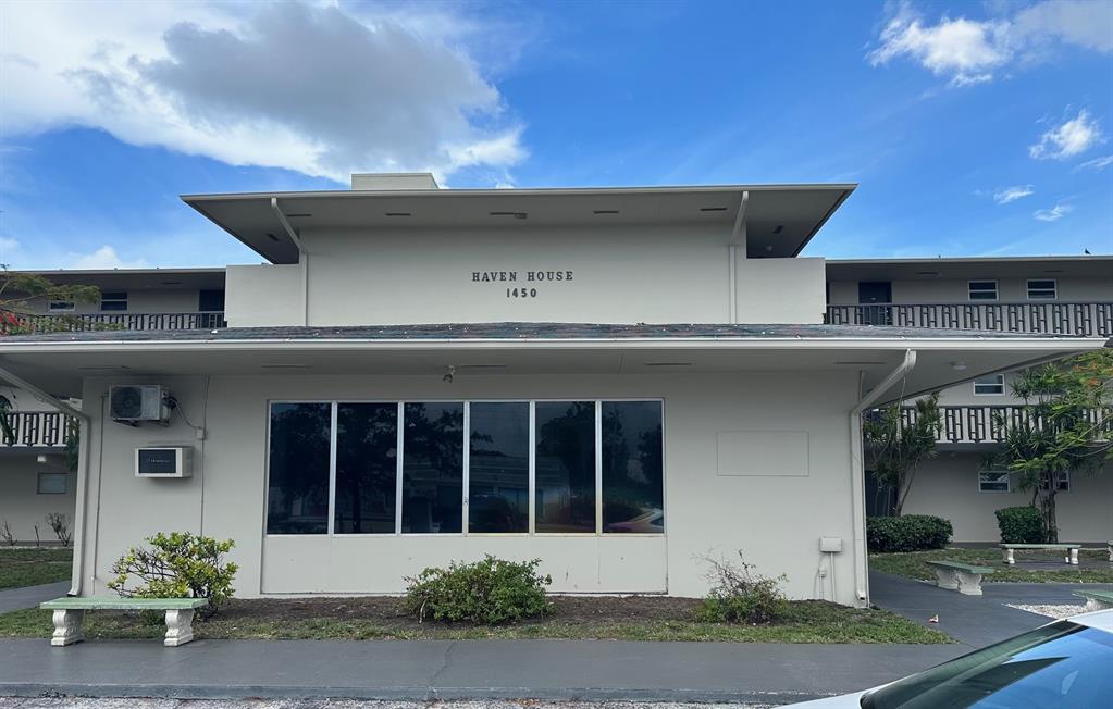1450 East Sample Road, Unit 104 Pompano Beach, FL 33064 - Photo 1 of 1 a front view of a house with a yard