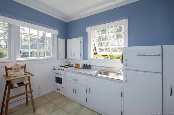 a kitchen with stainless steel appliances granite countertop a stove a cabinets and chairs