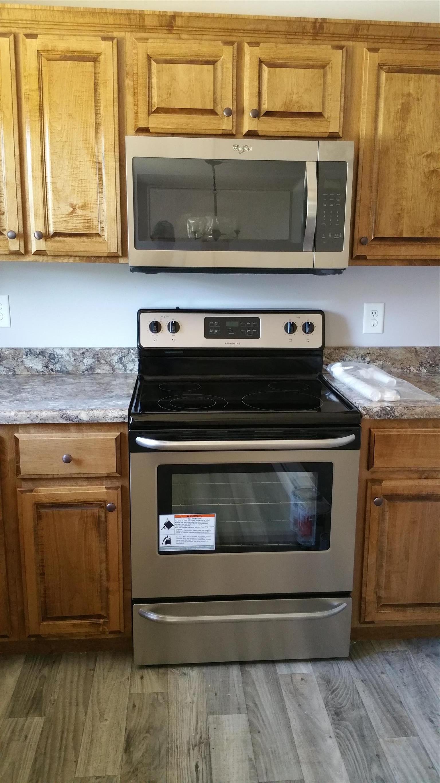 1227 East Ab Wade Road Portland, TN 37148 - Photo 4 of 9 a kitchen with granite countertop cabinets stove and microwave