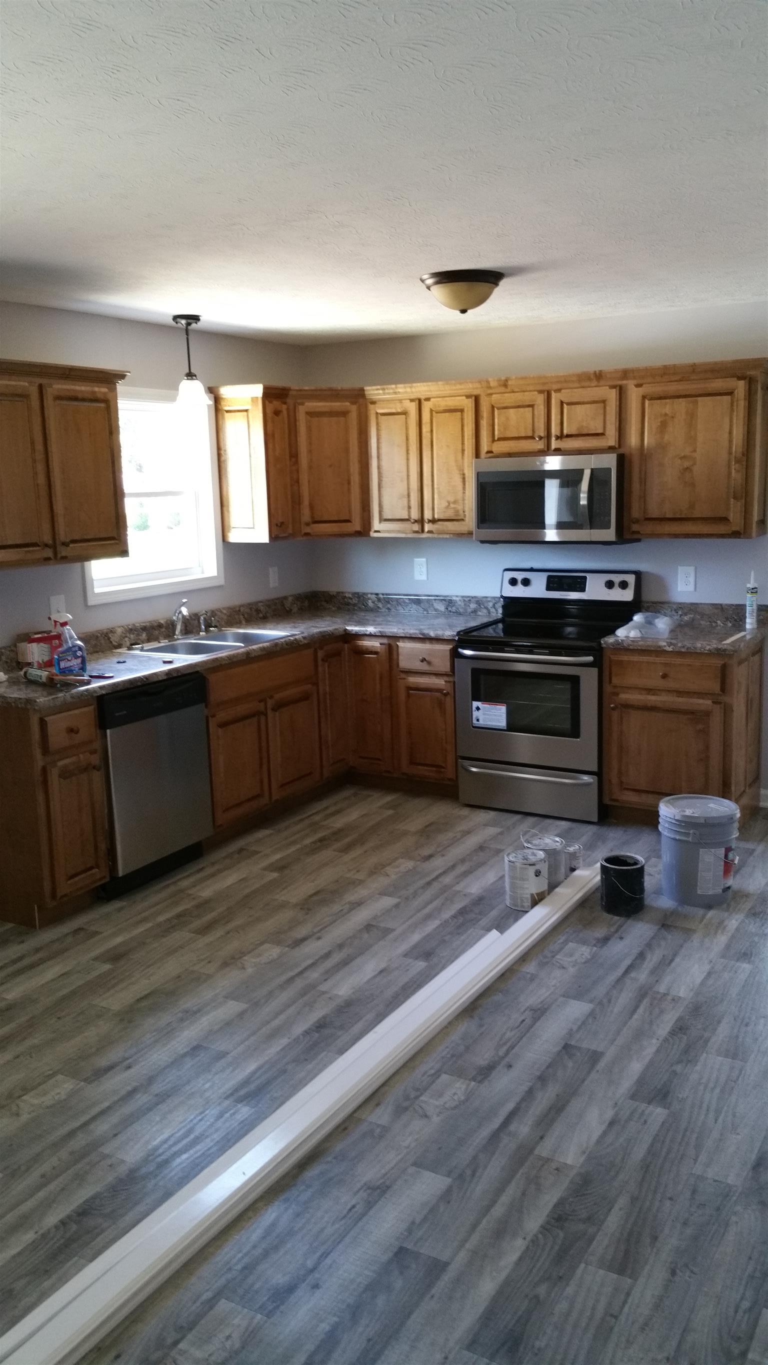 1227 East Ab Wade Road Portland, TN 37148 - Photo 5 of 9 a large kitchen with stainless steel appliances granite countertop a stove and a wooden floors