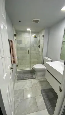 a bathroom with a double vanity sink toilet and shower