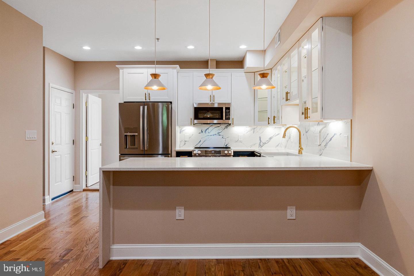 1609 17th Street Southeast, Unit 202 Washington, DC 20020 - Photo 2 of 19 a living room with stainless steel appliances kitchen island granite countertop a kitchen view living room and wooden floor