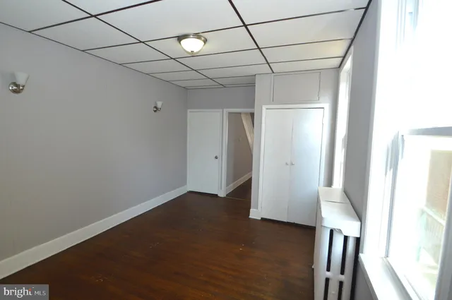 a view of a room with wooden floor and a window